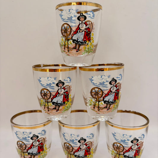 Set of six shot glasses with decorative designs on a white background