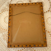 Back of a wooden picture frame with metal nails on a lace background