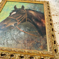 Painting of a horse in a decorative gold frame on a textured surface