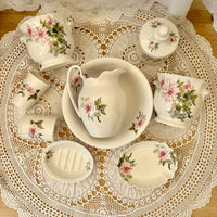Set of ceramic dishes with floral patterns on a lace doily