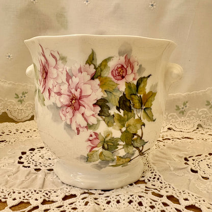 Decorative ceramic vase with floral design on a lace tablecloth