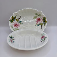 White ceramic soap dish with floral designs on a white background