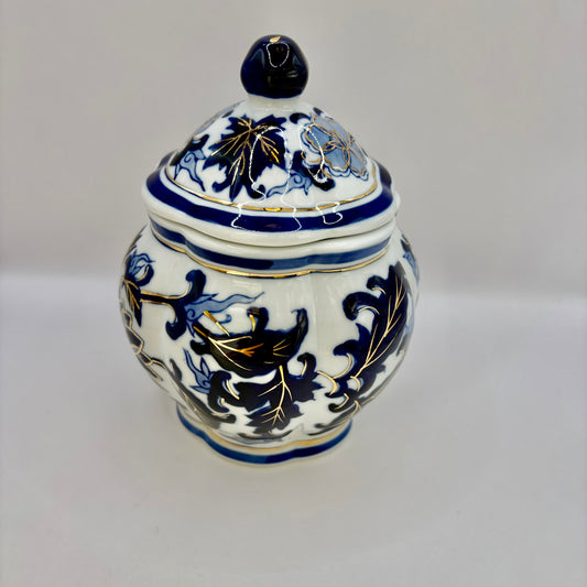 Decorative ceramic jar with blue and black floral patterns on a white background
