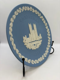 Decorative plate with a castle design on a stand against a white background