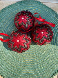 Decorative red and brown ornaments with ribbons on a textured green surface