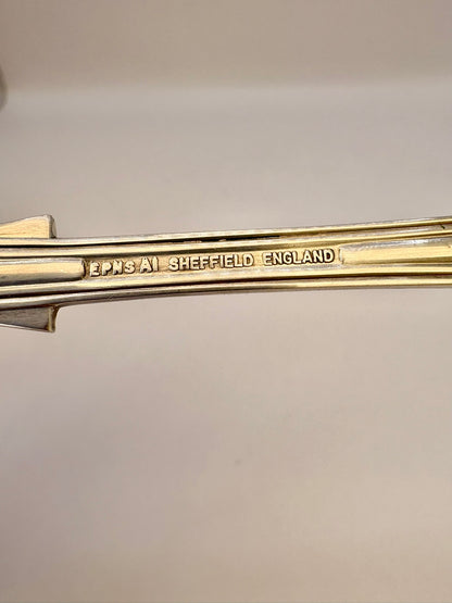 Gold object with 'Lonsdale Sheffield England' engraving on a light gray background