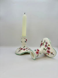 Ceramic candle holder with floral design on a white background
