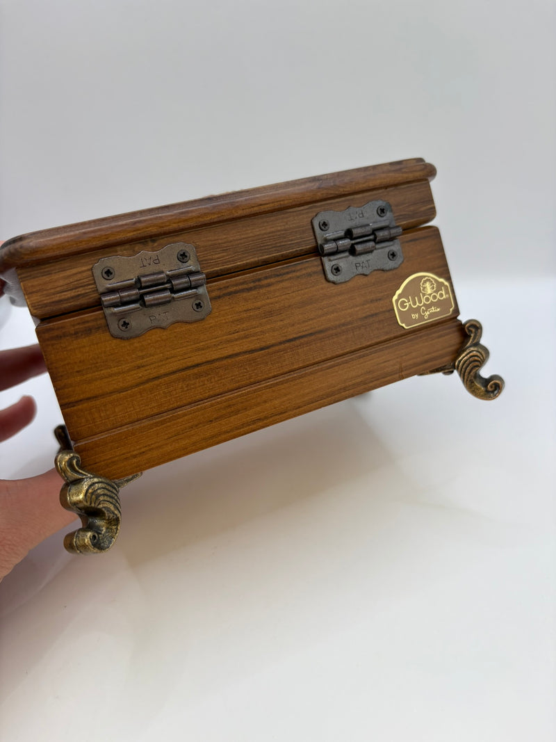 Wooden jewelry box with brass accents on a white background