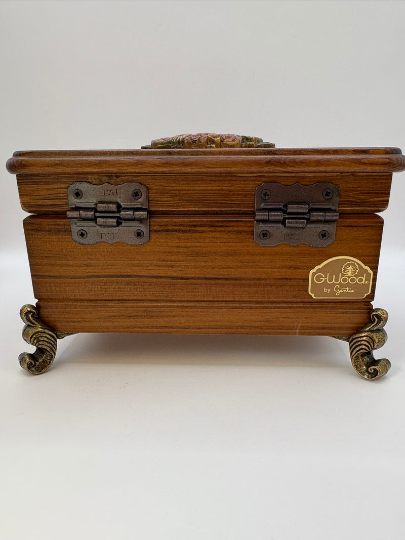 Wooden jewelry box with metal hinges and feet on a white background