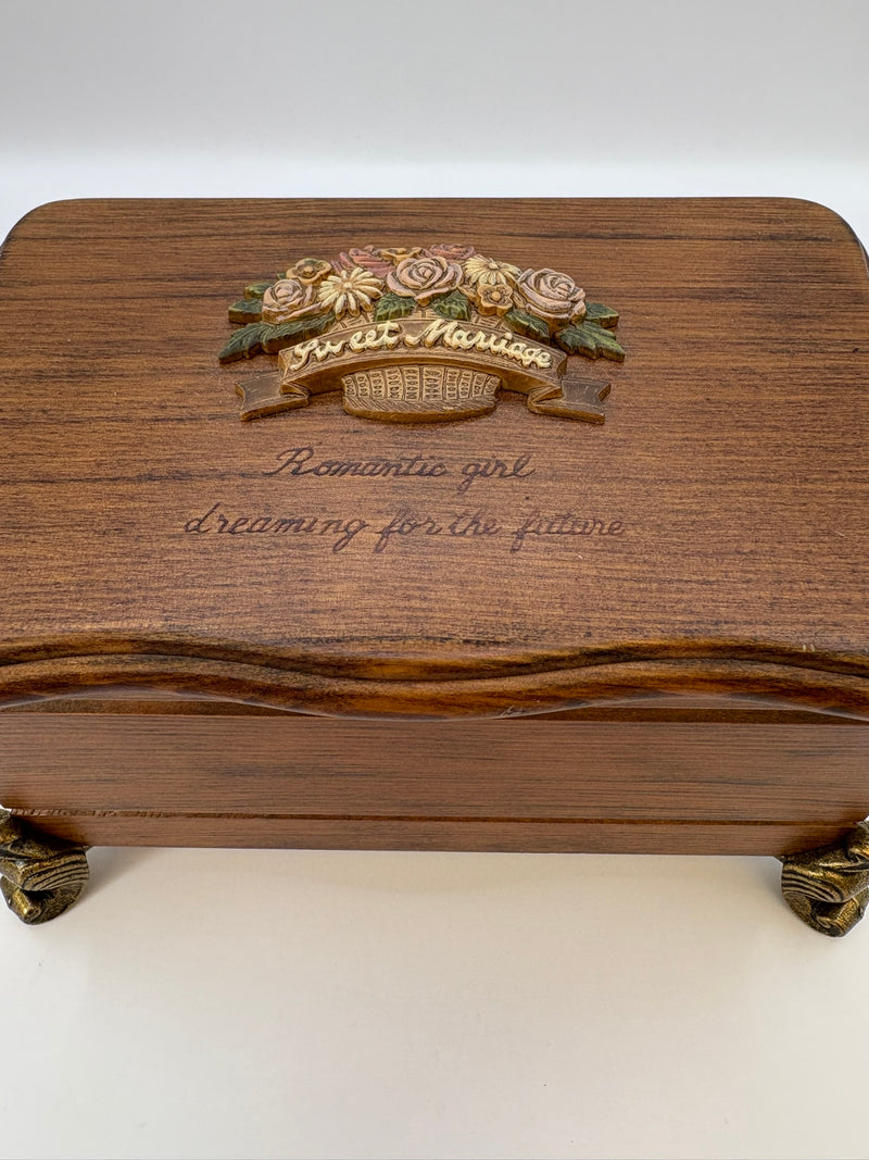 Wooden jewelry box with floral design and engraved text on a white background