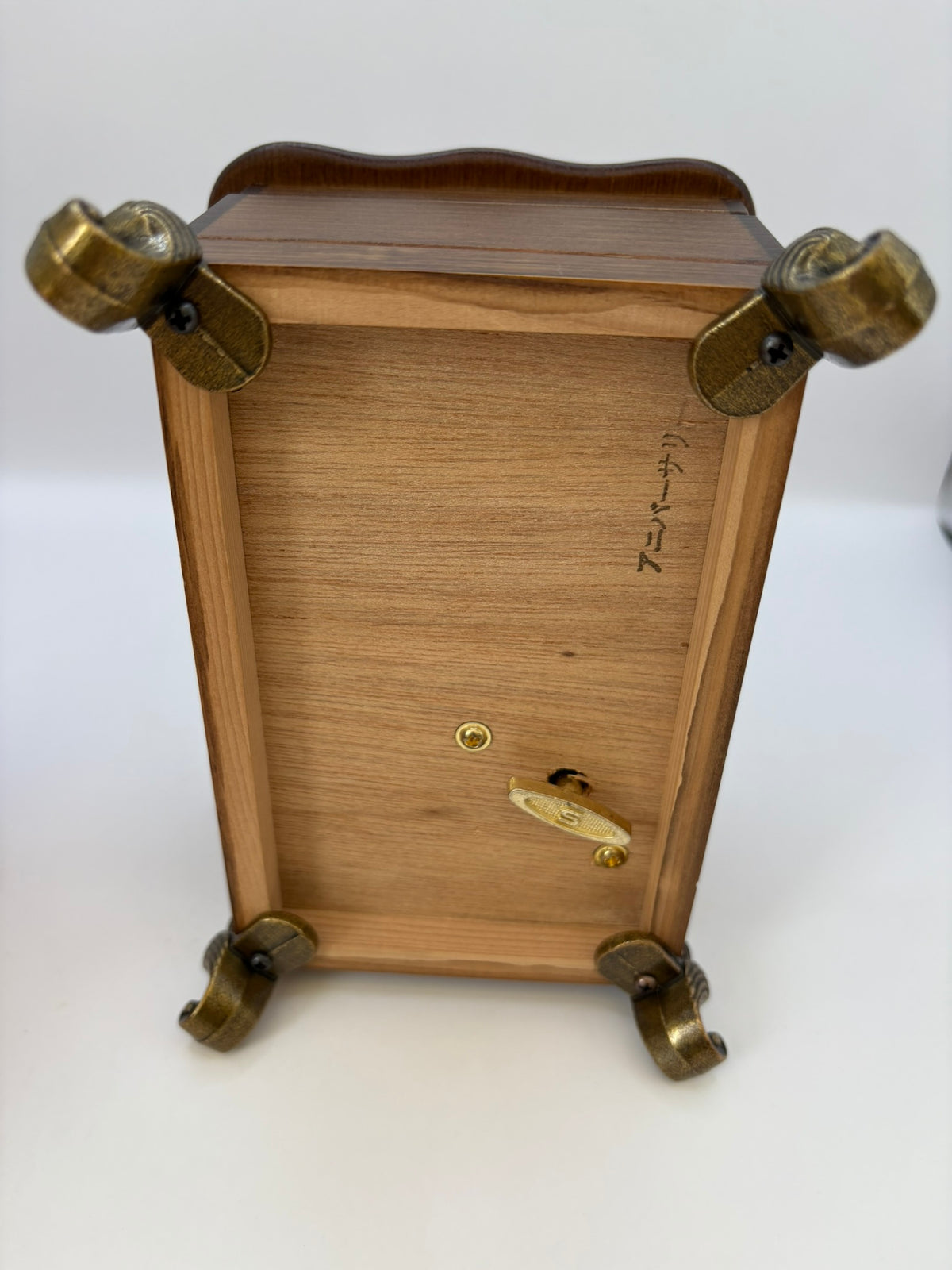 Wooden box with brass feet on a white background