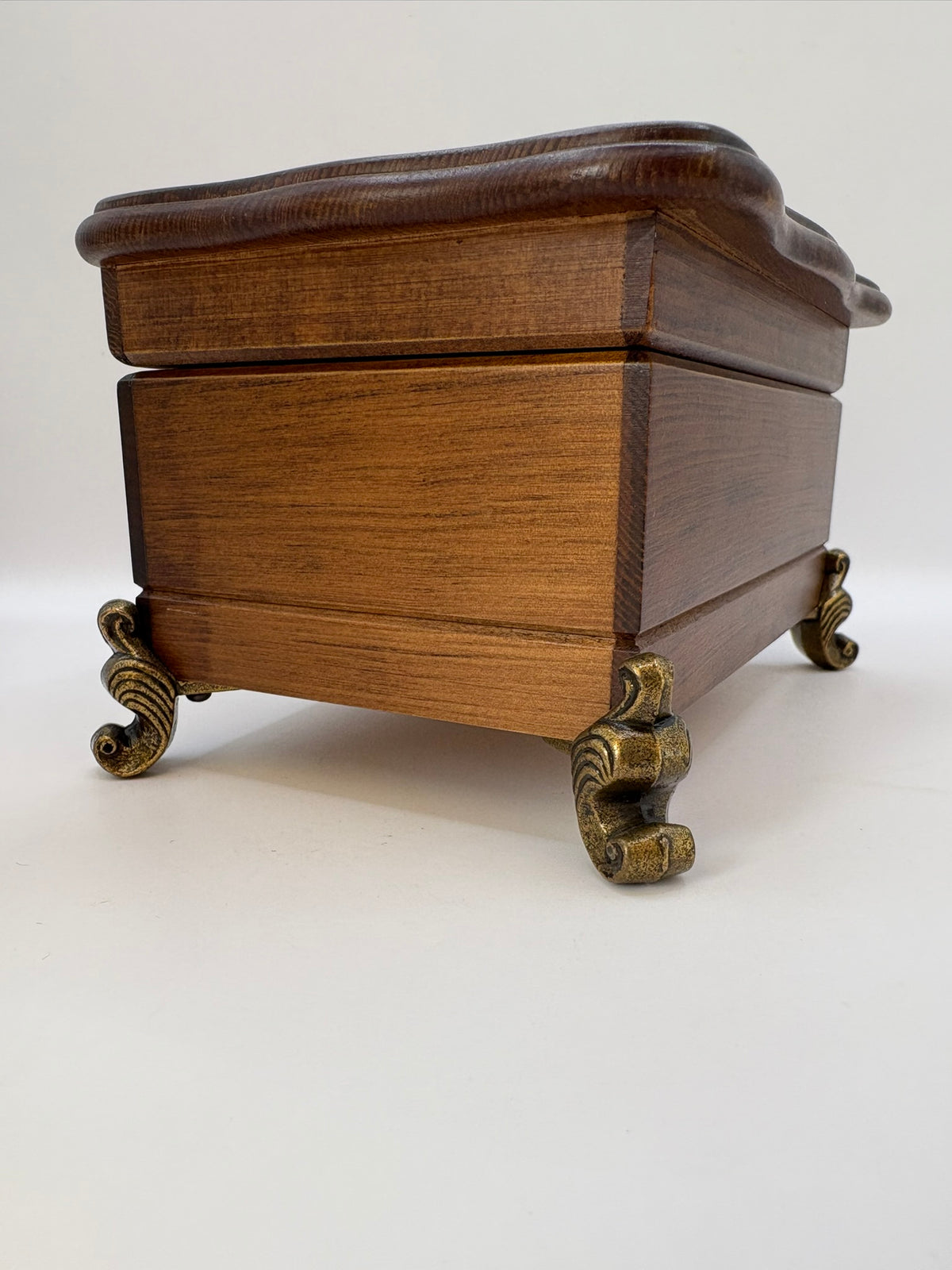 Wooden jewelry box with brass feet on a white background