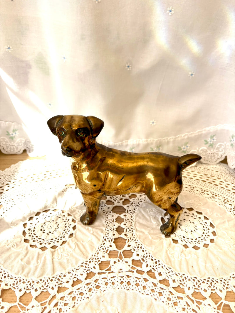 Bronze dog figurine on a lace doily with a white background