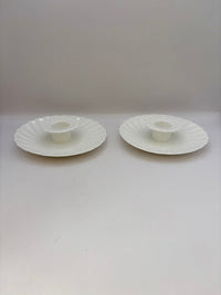 Two white ceramic candle holders on a white background