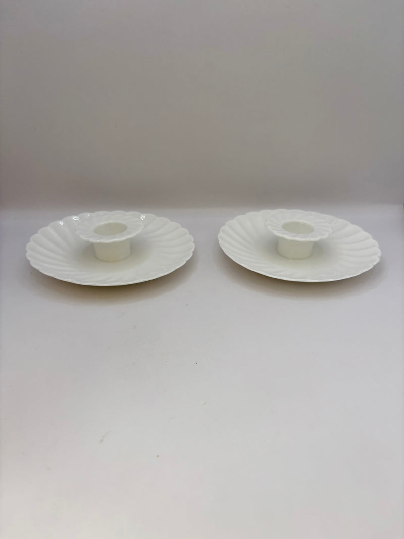 Two white ceramic candle holders on a white background