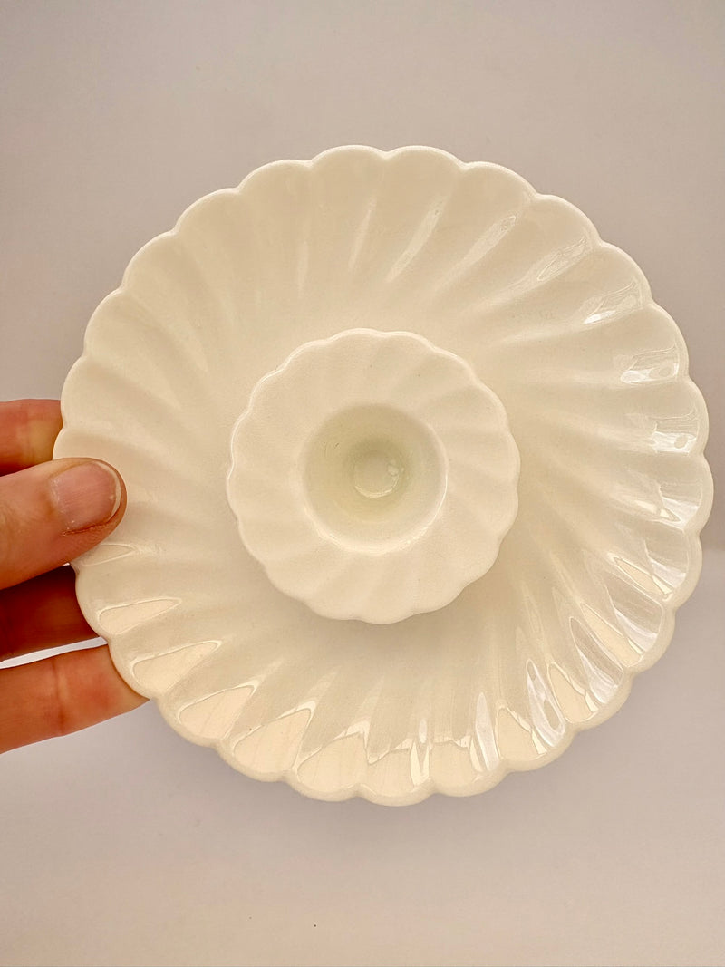 White ceramic dish held by a hand against a plain background