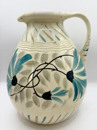 Ceramic pitcher with floral design on a white background