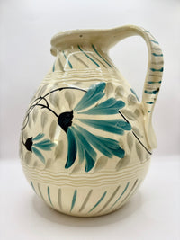Ceramic pitcher with floral design on a white background
