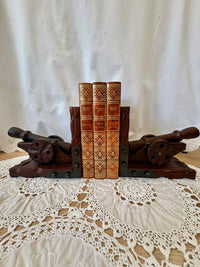 Wooden bookends with decorative books on a lace tablecloth