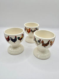 Three egg cups with chicken design on a white background