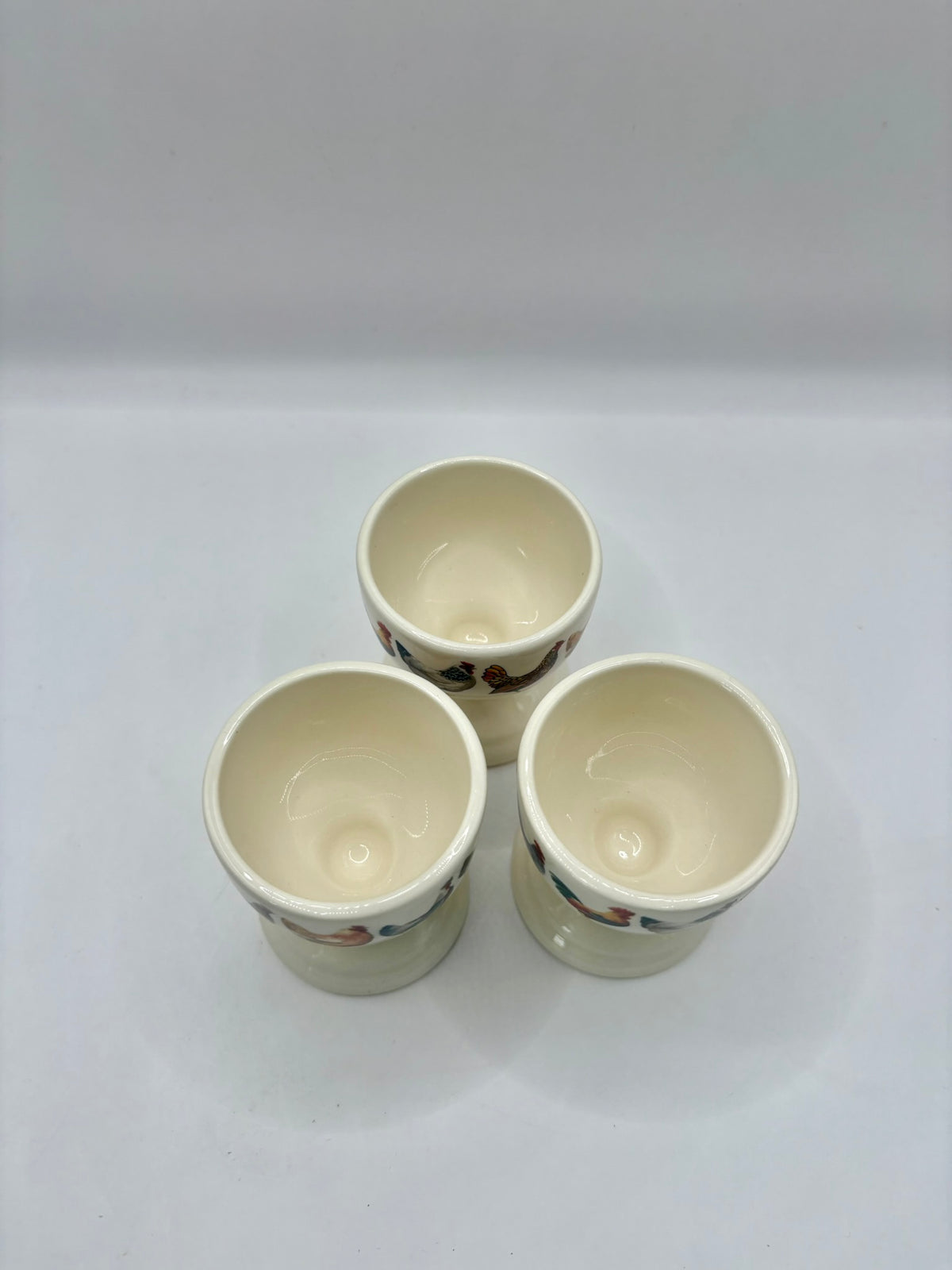 Three ceramic cups with floral patterns on a white background