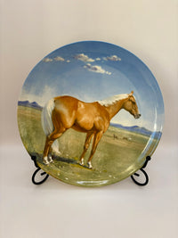 Decorative plate with a horse painting on a stand against a plain background