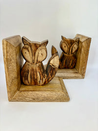 Wooden foxes bookends on a white background