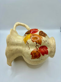 Ceramic vase with autumn leaf design on a white background