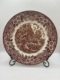 Decorative plate with brown floral and landscape design on a white background