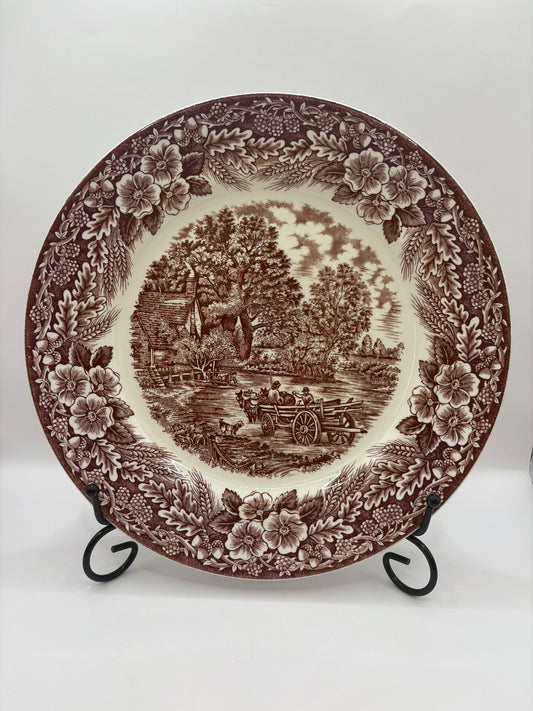 Decorative plate with brown floral and landscape design on a white background
