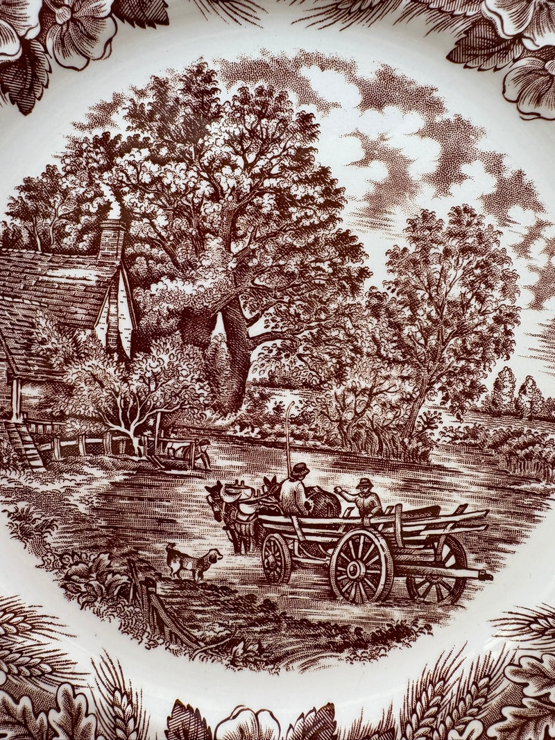 Vintage-style illustration of a rural scene with a cart and people, surrounded by trees and buildings.