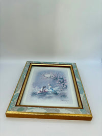 Framed artwork of a couple in a snowy landscape on a white background