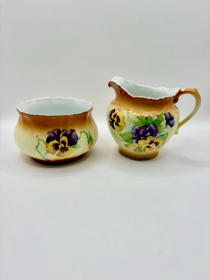 Two ceramic containers with floral designs on a white background