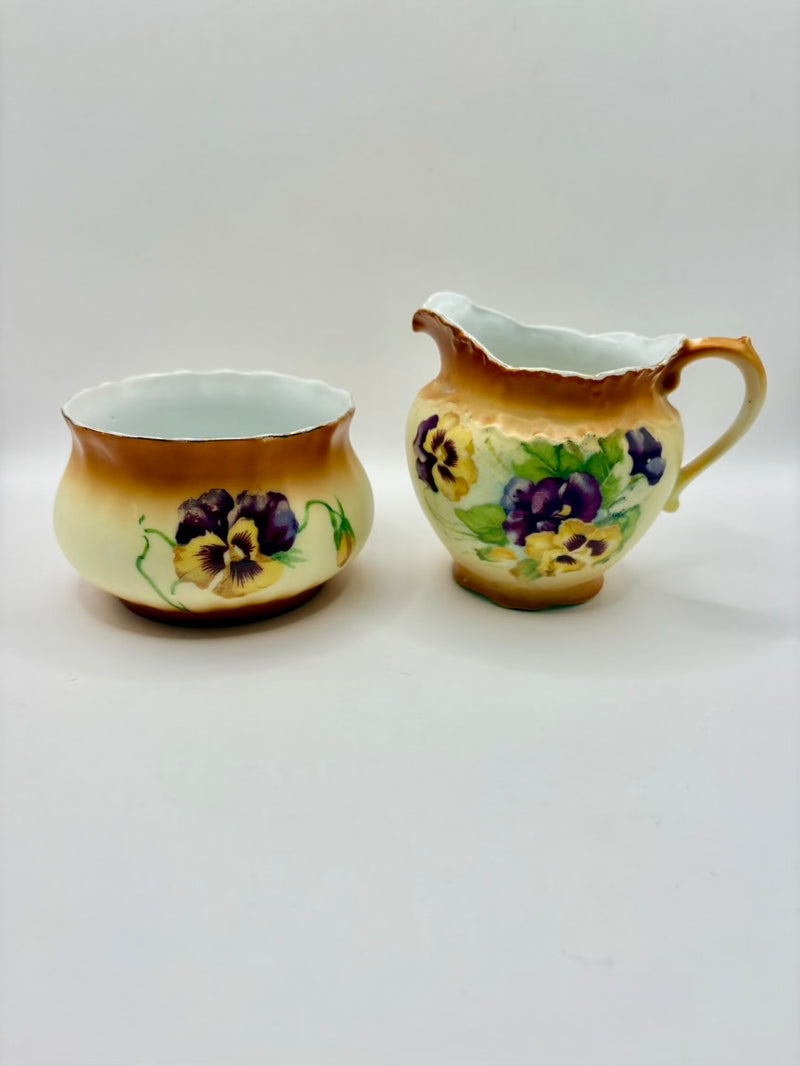 Two ceramic containers with floral designs on a white background