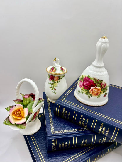 Decorative items including a bell, small basket, and books with floral designs on a white background