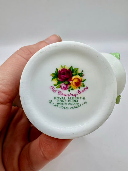 White ceramic dish with floral design and 'Royal Albert' branding held by a hand on a white background