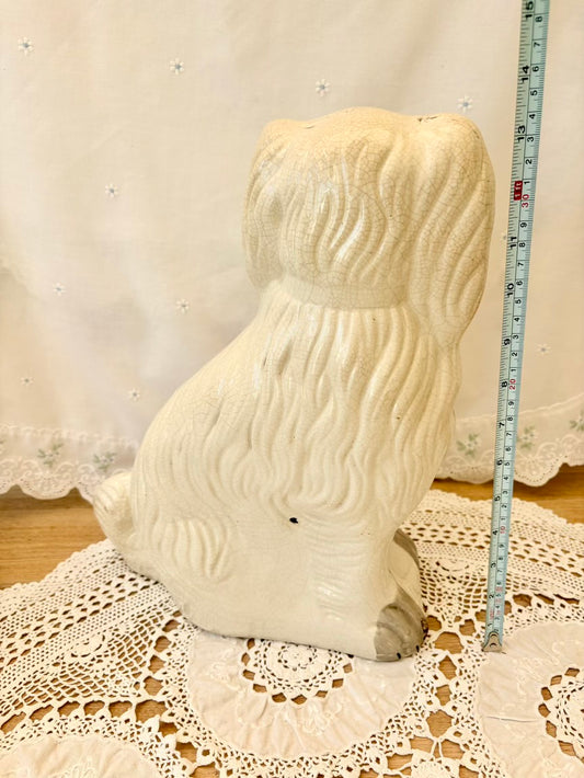 White decorative item with a textured surface on a lace tablecloth, accompanied by a measuring tape.