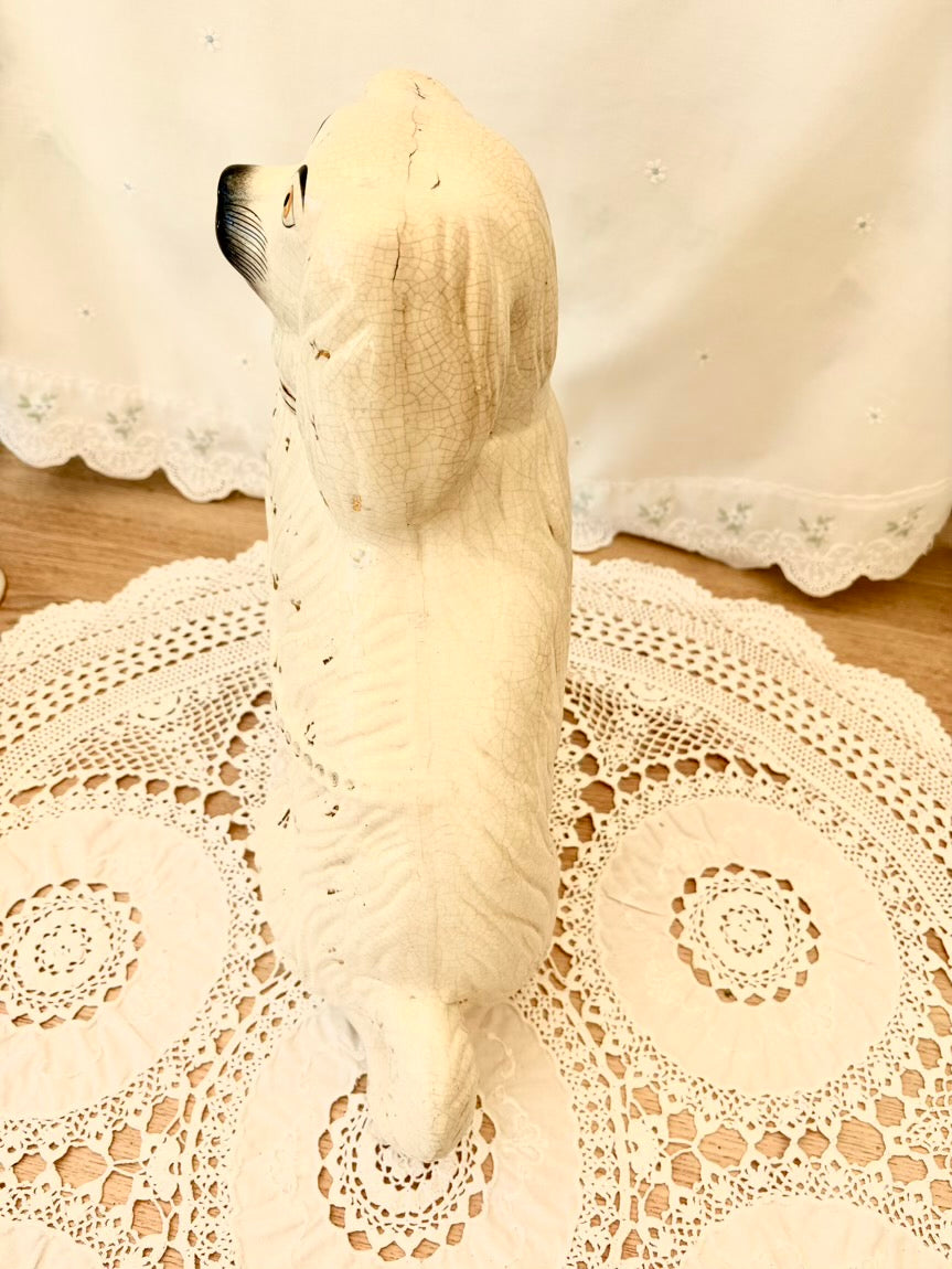 White dog figurine on a lace doily with a blurred background