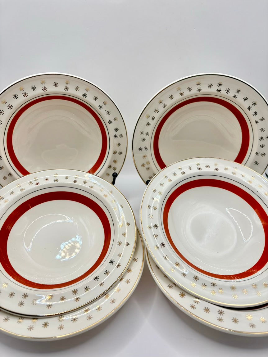 Six ceramic plates with red and gold decorative rims on a white background