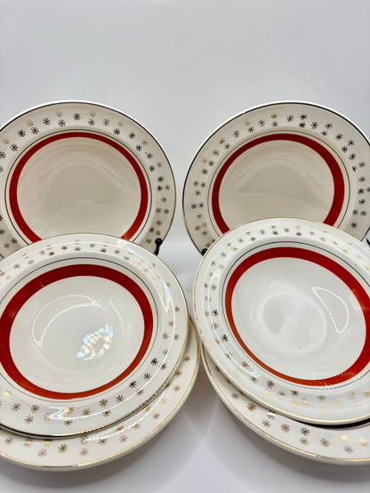 Six ceramic plates with red and gold decorative rims on a white background