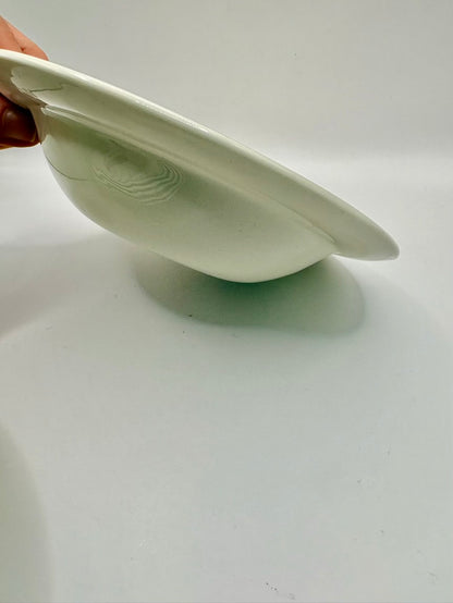 White ceramic plate held by a hand on a light gray background