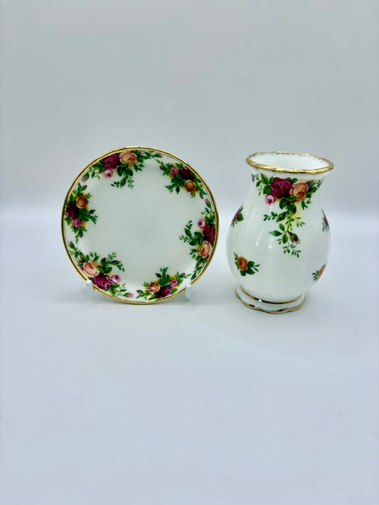 Small white vase and plate with floral patterns on a light gray background