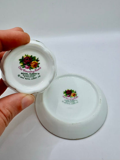 Two small white ceramic items with floral designs and text on a white background.