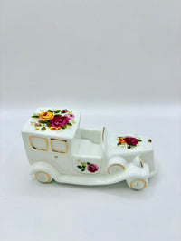 Decorative ceramic toy truck with floral designs on a white background
