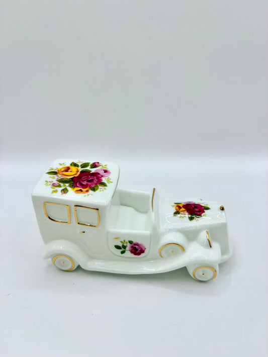 Decorative ceramic toy truck with floral designs on a white background