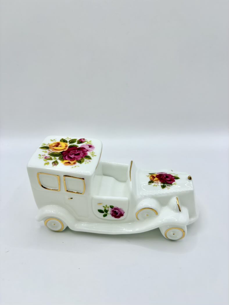 Decorative ceramic toy truck with floral designs on a white background