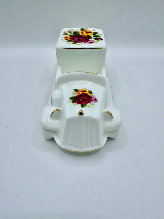 White ceramic miniature toilet with floral design on a white background
