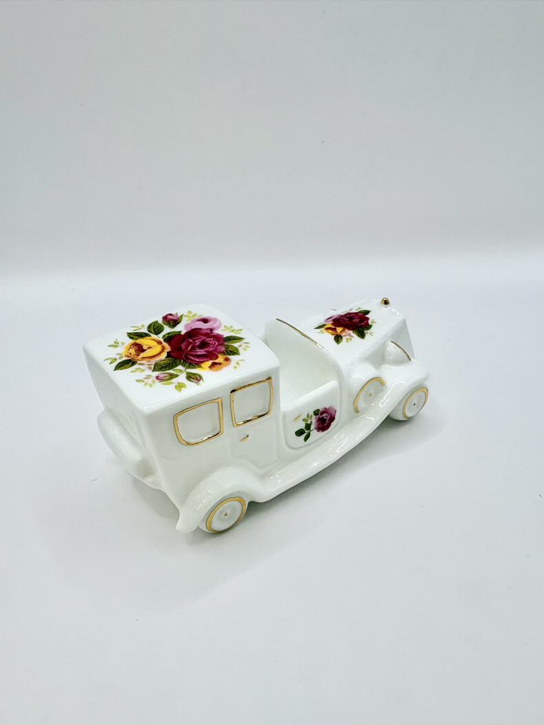Decorative ceramic toy truck with floral designs on a white background