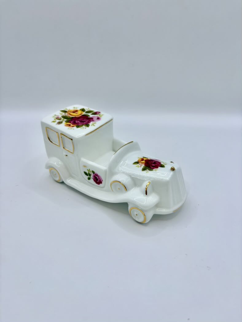 Decorative ceramic car with floral designs on a white background