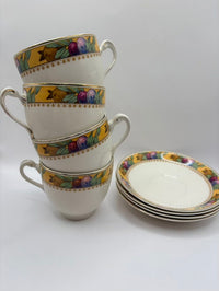 Set of ceramic cups and saucers with decorative borders on a white background